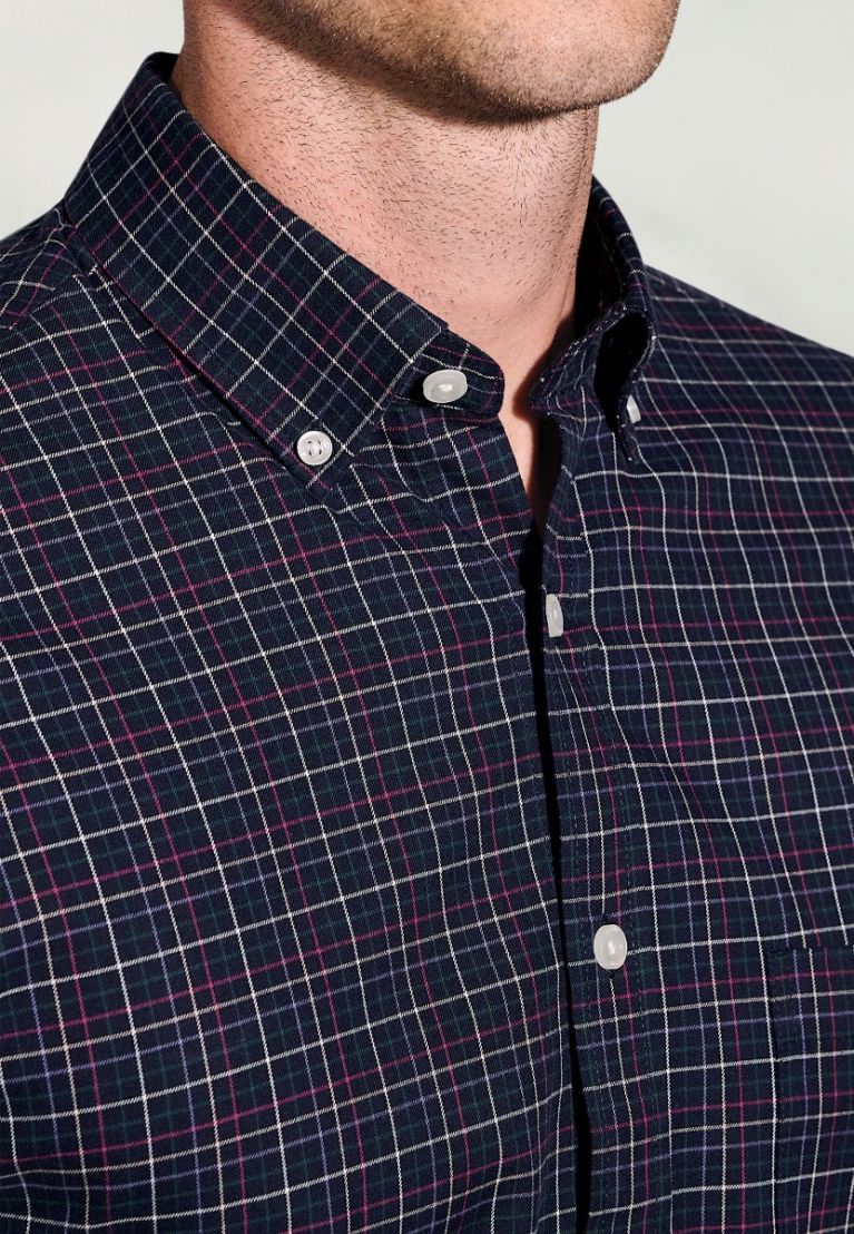 Navy and red checkered shirt with button details on a plain background